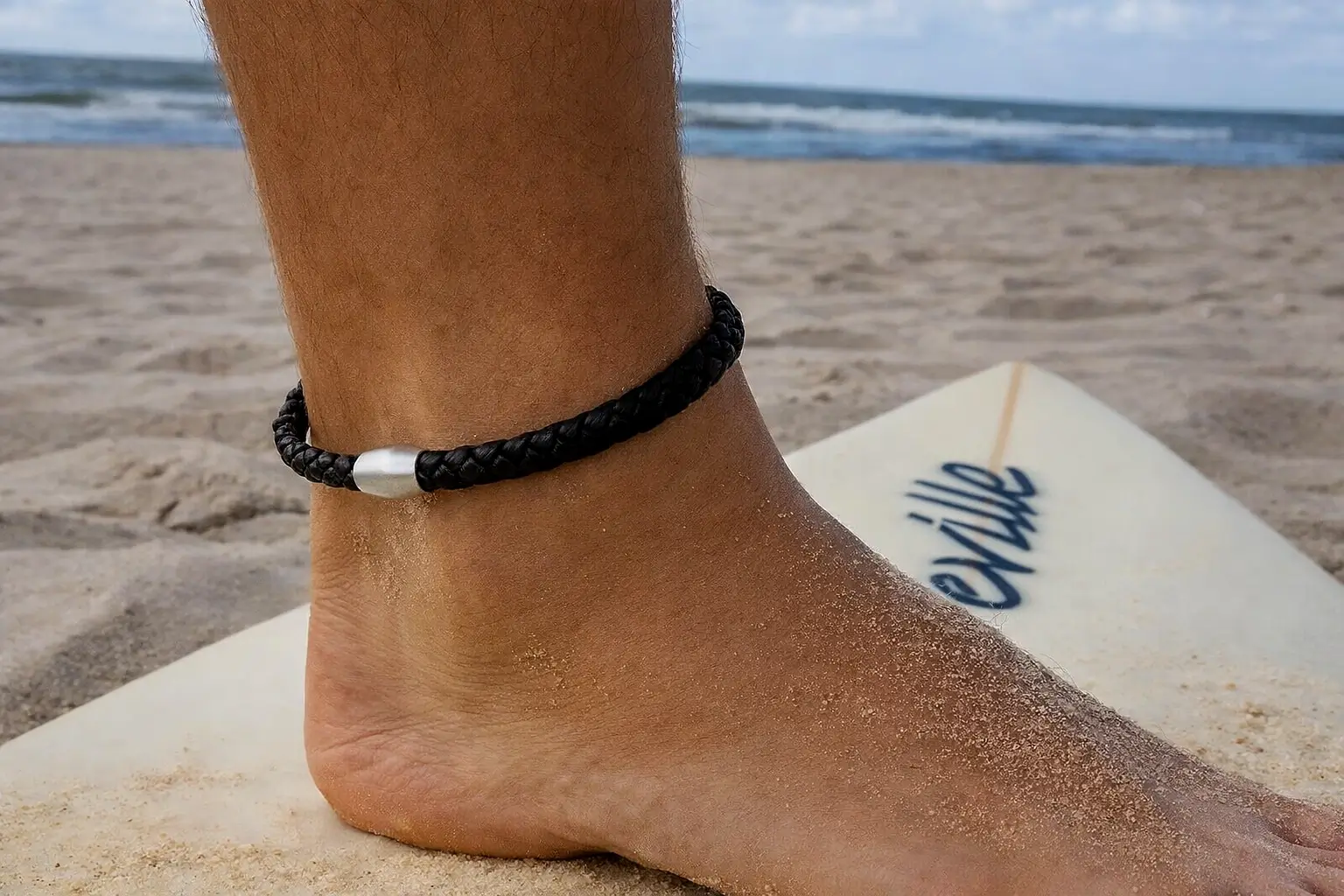 Tobillera de cuero surfista en la playa con estilo natural inspirado en el océano.