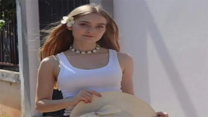 Mujer con collar de conchas en cuero trenzado; estilo surfer, luz natural