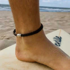 Tobillera de cuero para surfista en la playa con estilo natural inspirado en el océano.