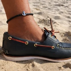 Tobillera de cuero con ancla estilo surfista usada en la playa